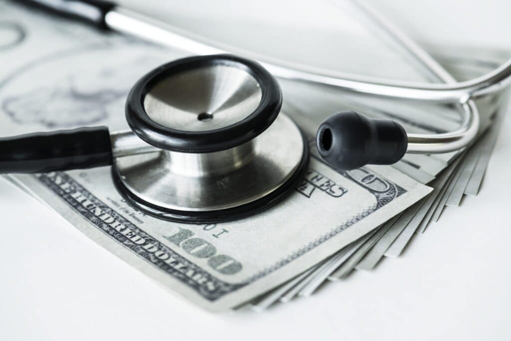 Closeup of cash and a stethoscope healthcare and expenses